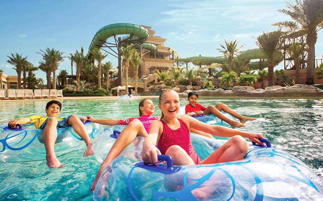 Children enjoying a lazy river ride at Aquaventure Waterpark, Dubai.