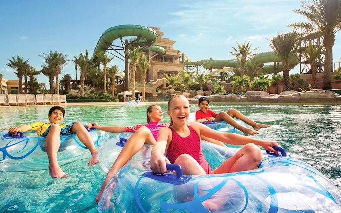 Children enjoying a lazy river ride at Aquaventure Waterpark, Dubai.