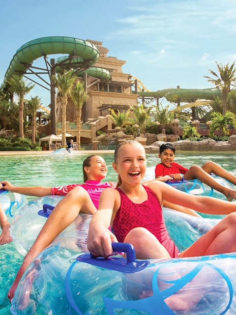 Children enjoying a lazy river ride at Aquaventure Waterpark, Dubai.