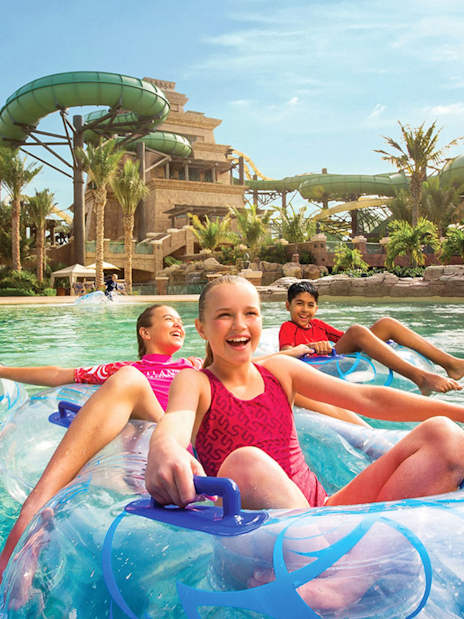 Children enjoying a lazy river ride at Aquaventure Waterpark, Dubai.