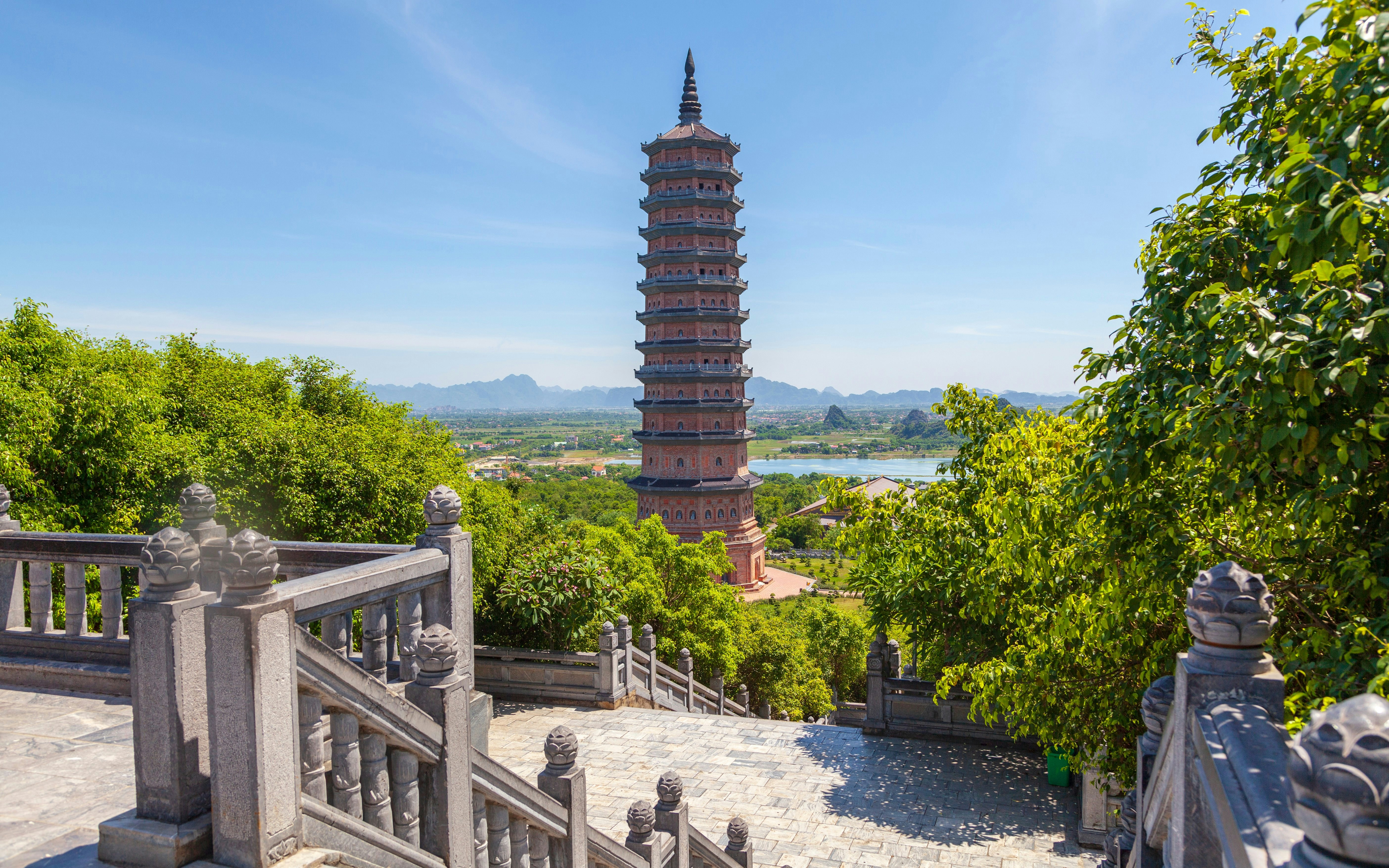 Bai Dinh Pagoda tower surrounded by lush greenery in Ninh Binh, Vietnam.