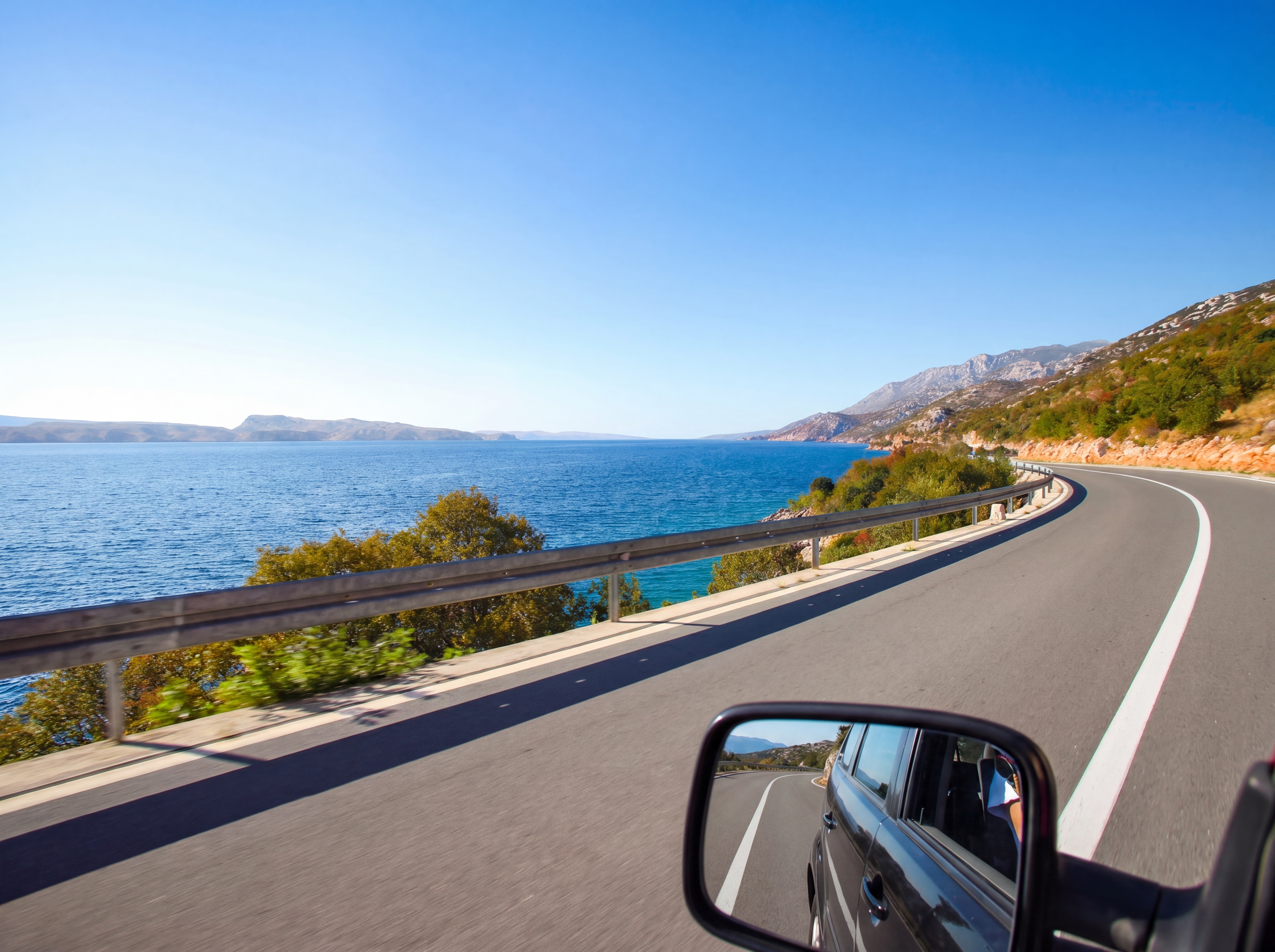Driving along the scenic Croatian coast with ocean views and winding roads.