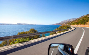 Driving along the scenic Croatian coast with ocean views and winding roads.