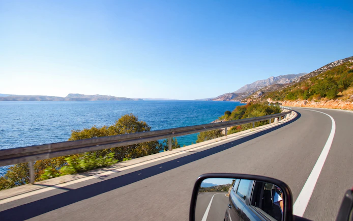 Driving along the scenic Croatian coast with ocean views and winding roads.