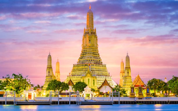 Wat Arun temple illuminated at sunset in Bangkok, Thailand.