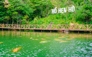 Wooden bridge over a pond with "Hồ Hen Hồ" sign, O Quy Ho Fairy Heaven Gate, Sa Pa.