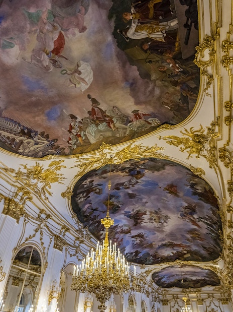 Ornate ceiling frescoes and chandeliers in Schönbrunn Palace, Vienna.