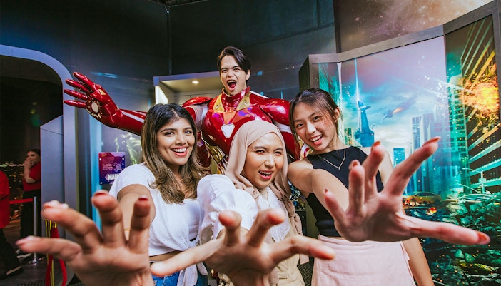Visitors posing with Iron Man at Madame Tussauds Singapore's Marvel Universe 4D exhibit.