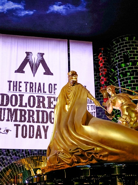 Trial banner and golden statue at Harry Potter and the Battle at the Ministry, Epic Universe, Orlando.