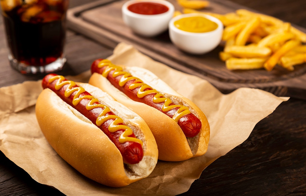 Hot dogs with ketchup and mustard, served with french fries and a soda.