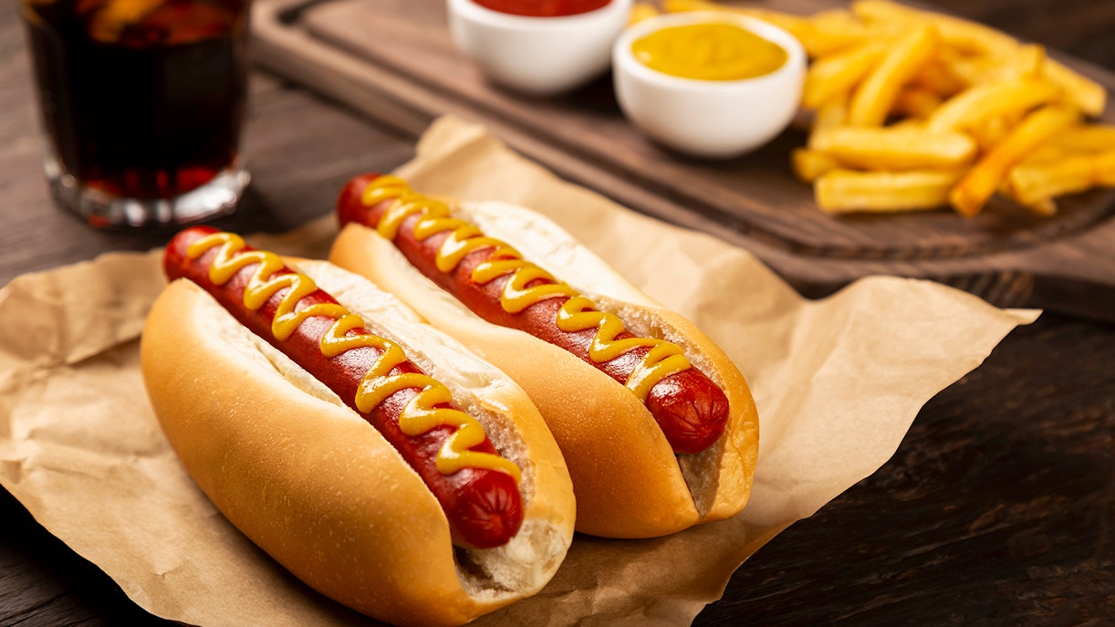 Hot dogs with ketchup and mustard, served with french fries and a soda.