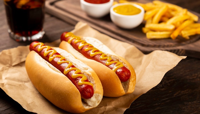 Hot dogs with ketchup and mustard, served with french fries and a soda.