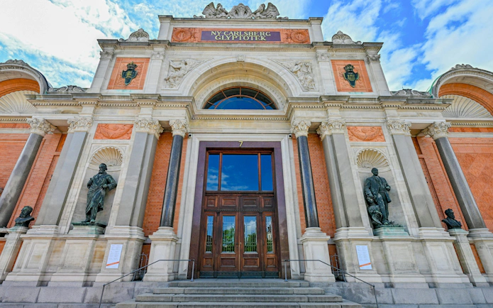 Entrance of New Carlsberg Glyptotek with statues and ornate architecture, Copenhagen, Denmark.