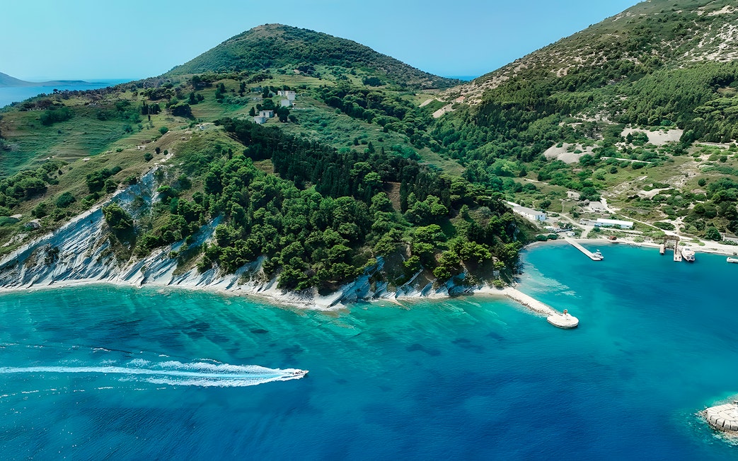 Aerial view of Vlora coastline with a pirate boat tour in Albania's Ionian Sea.