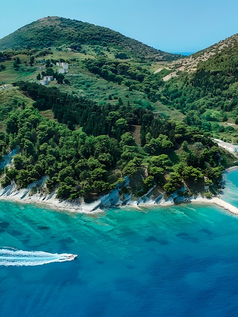 Aerial view of Vlora coastline with a pirate boat tour in Albania's Ionian Sea.
