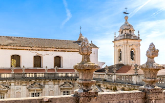 Terrace view of the Church of Graça with bell tower, Lisbon skyline in background.