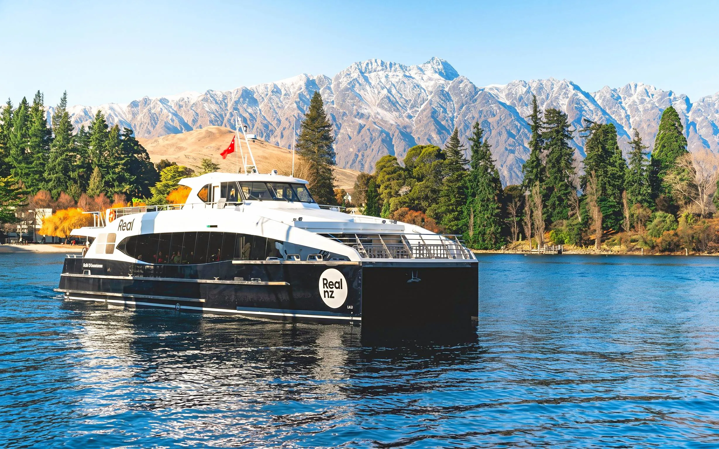 Cruise boat on Lake Wakatipu with Remarkables mountain range in Queenstown.
