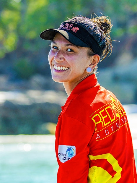 Tour guide smiling on Thundercat Whitsundays Full Day Tour, with beach and trees in background.