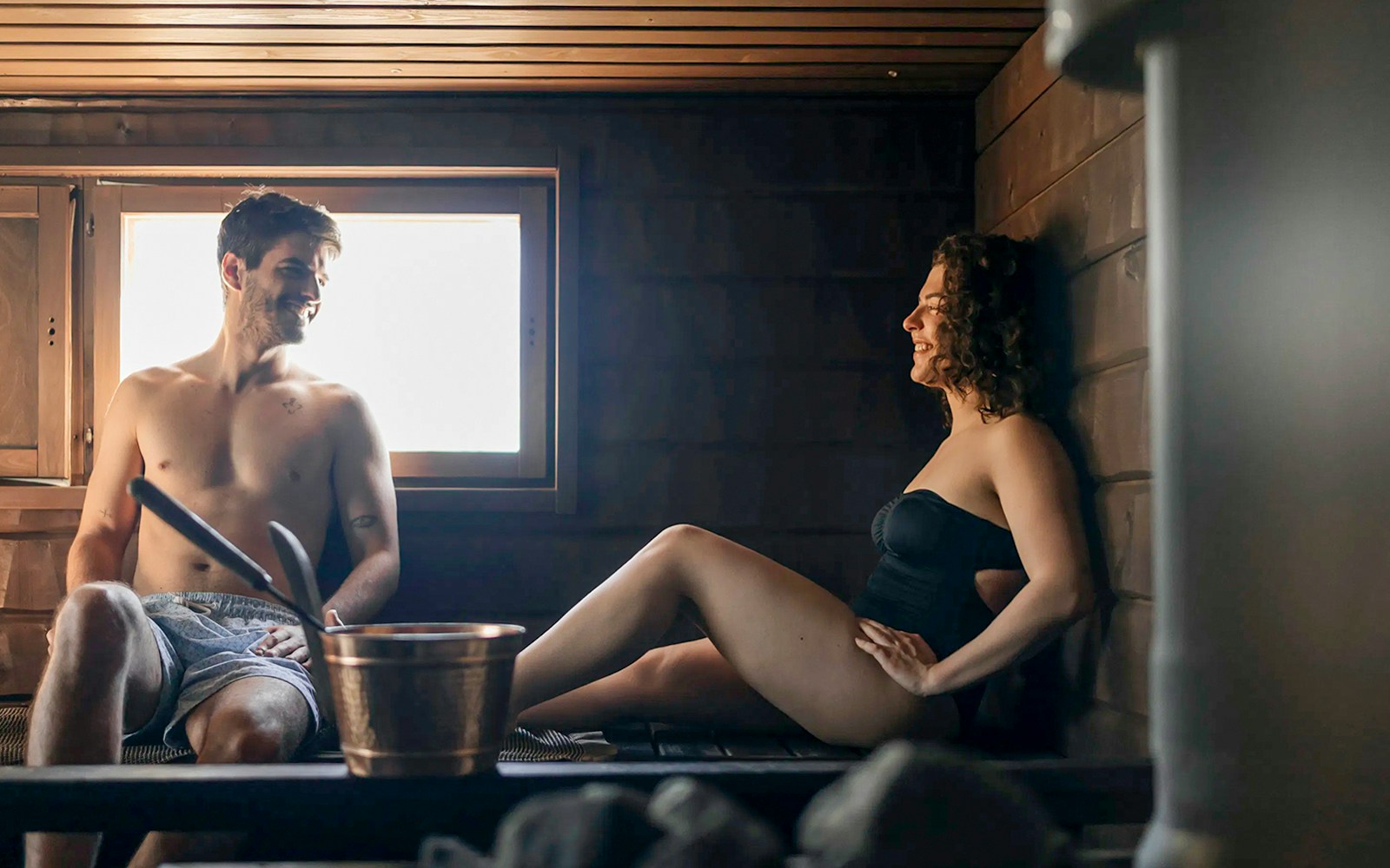 Guests relaxing in a sauna during Northern lights experience in Rovaniemi.