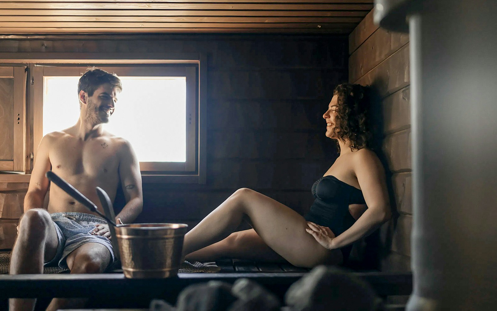 Guests relaxing in a sauna during Northern lights experience in Rovaniemi.