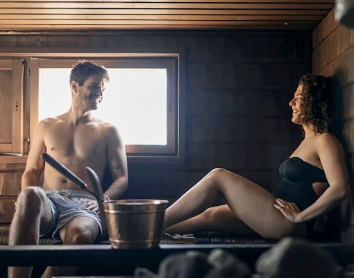 Guests relaxing in a sauna during Northern lights experience in Rovaniemi.