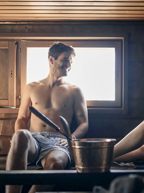 Guests relaxing in a sauna during Northern lights experience in Rovaniemi.
