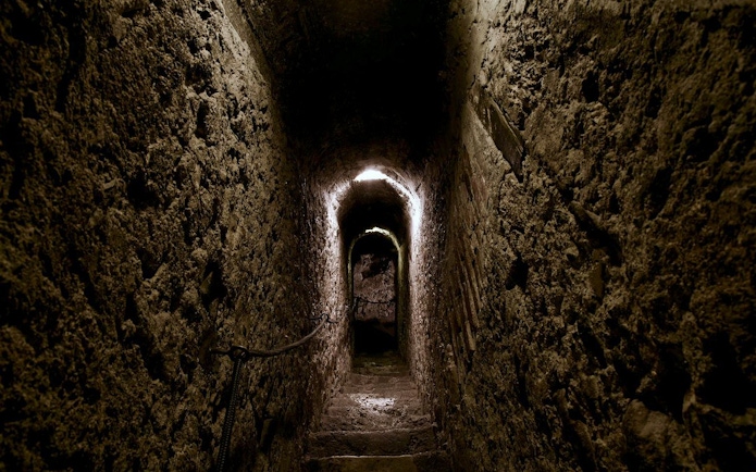 Bran Castle secret passageway with stone walls and dim lighting.