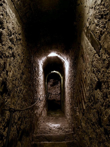 Bran Castle secret passageway with stone walls and dim lighting.