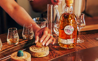 Roe & Co Distillery whiskey tasting setup with glasses and ingredients.