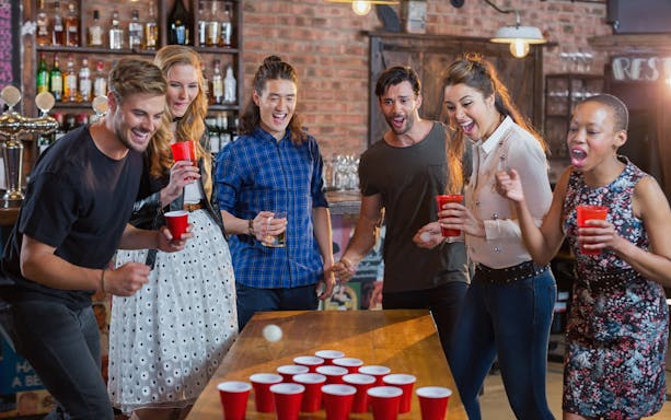 Group playing beer pong during a guided pub crawl in Rome.