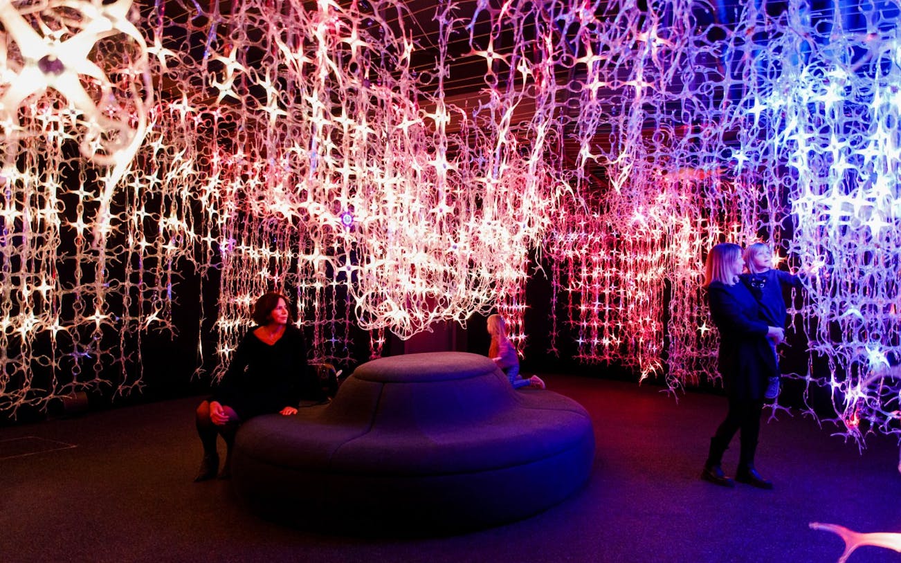 Guests explore light installations at Mythos Mozart Immersive Experience in Vienna.