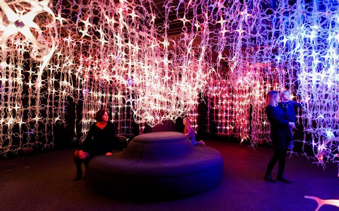 Guests explore light installations at Mythos Mozart Immersive Experience in Vienna.