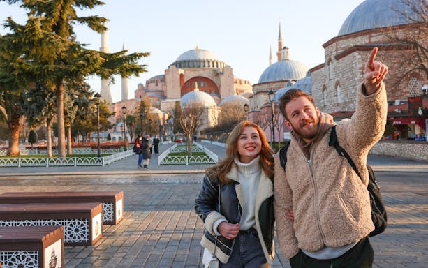 Tourists couple exploring Hagia Sophia Grand Mosque in Istanbul.