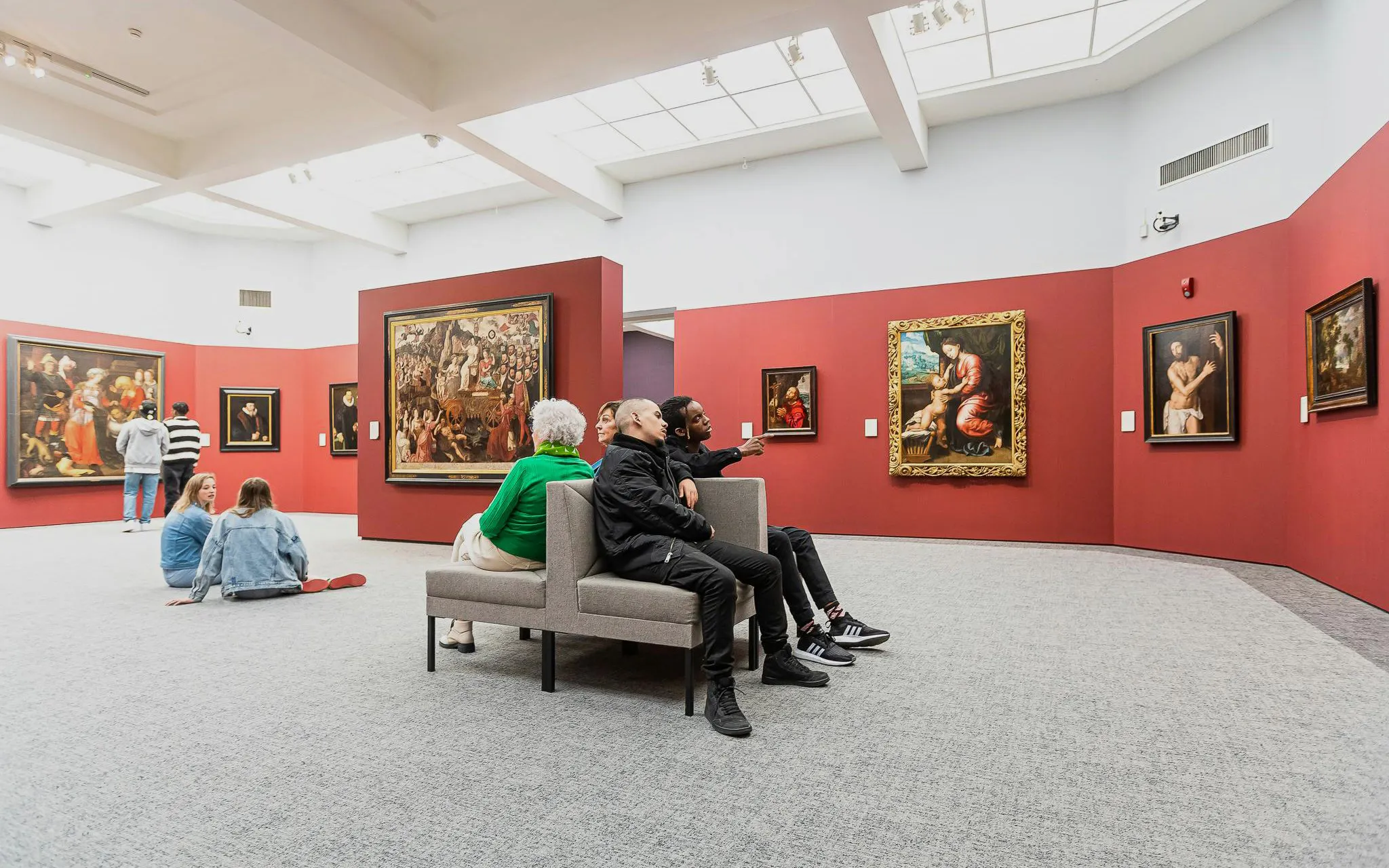 Visitors viewing art in Groeningemuseum gallery, Bruges.