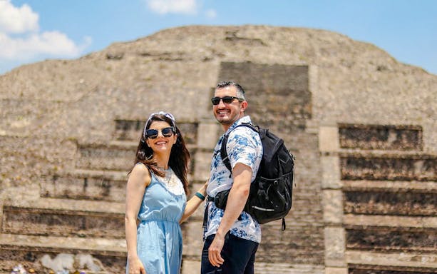Couple smiling in front of Pyramid of the Sun, Teotihuacán, during balloon flight tour.