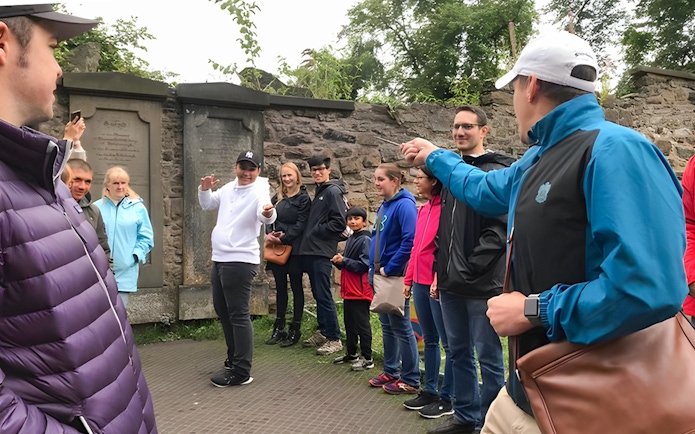 Group on Harry Potter walking tour with guide demonstrating wand technique.