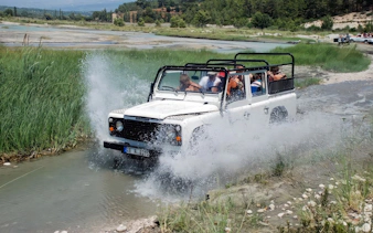 Jeep crossing a river during Alanya day-trip with tourists.