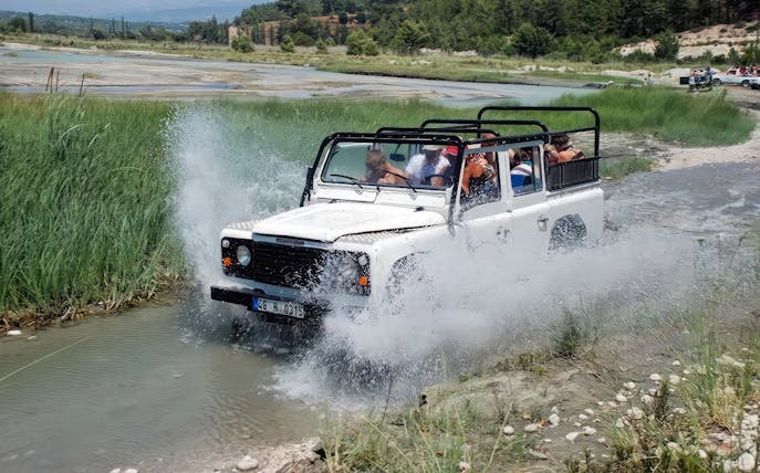 Jeep crossing a river during Alanya day-trip with tourists.