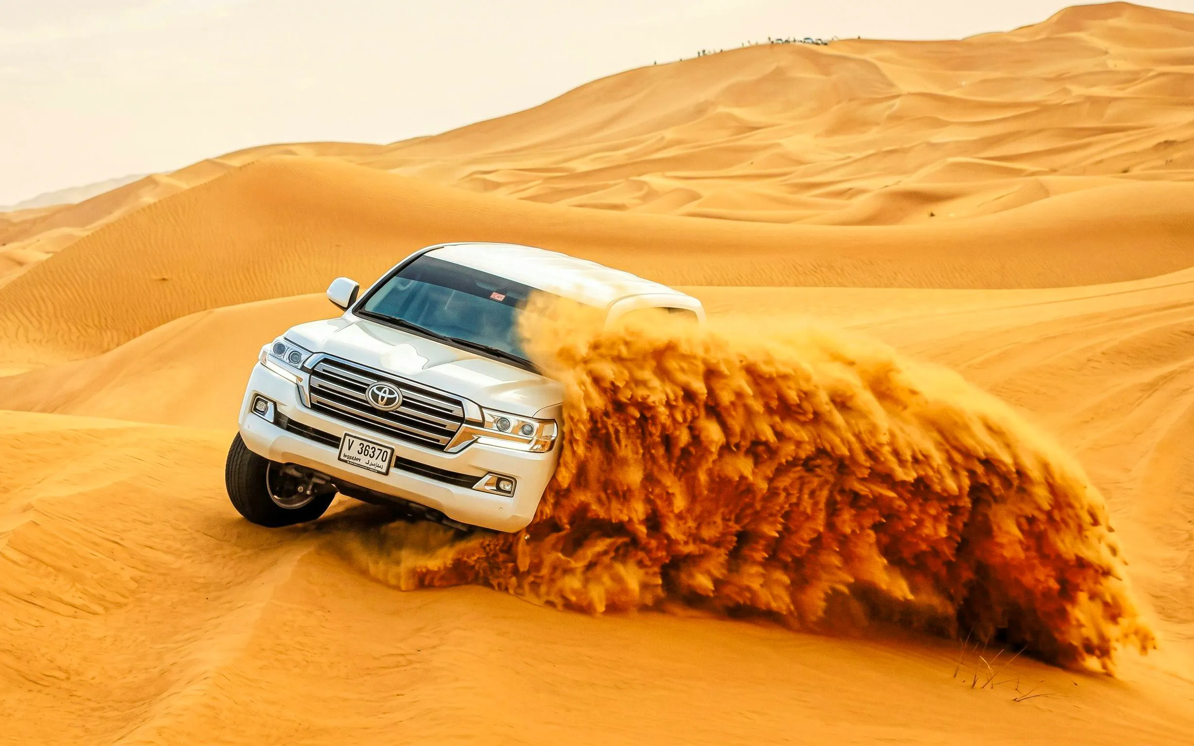 SUV driving through sand dunes on a Dubai Red Dunes Desert Safari.