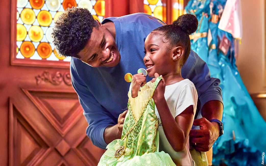 Child holding a princess dress at Disneyland Park, California.