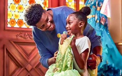 Child holding a princess dress at Disneyland Park, California.