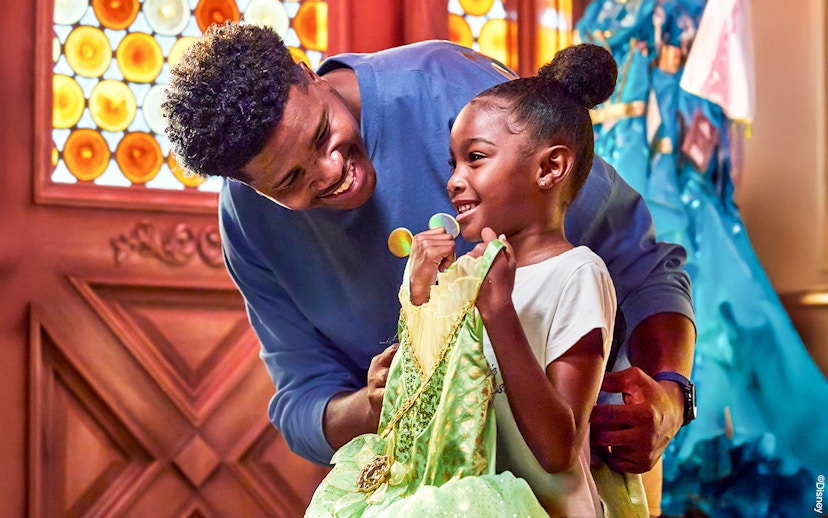 Child holding a princess dress at Disneyland Park, California.
