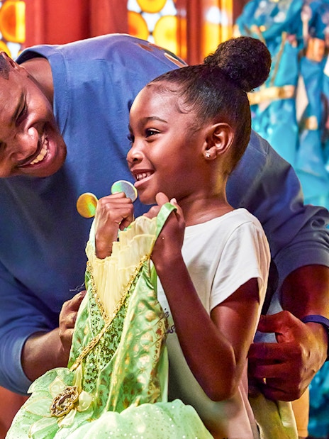 Child holding a princess dress at Disneyland Park, California.