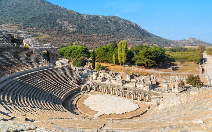 Ancient theater ruins in Ephesus, Turkey, with surrounding landscape.