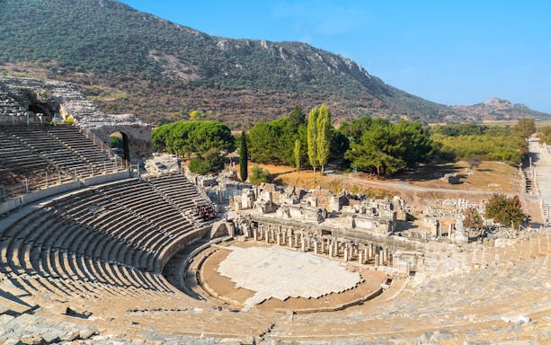 Ancient theater ruins in Ephesus, Turkey, with surrounding landscape.