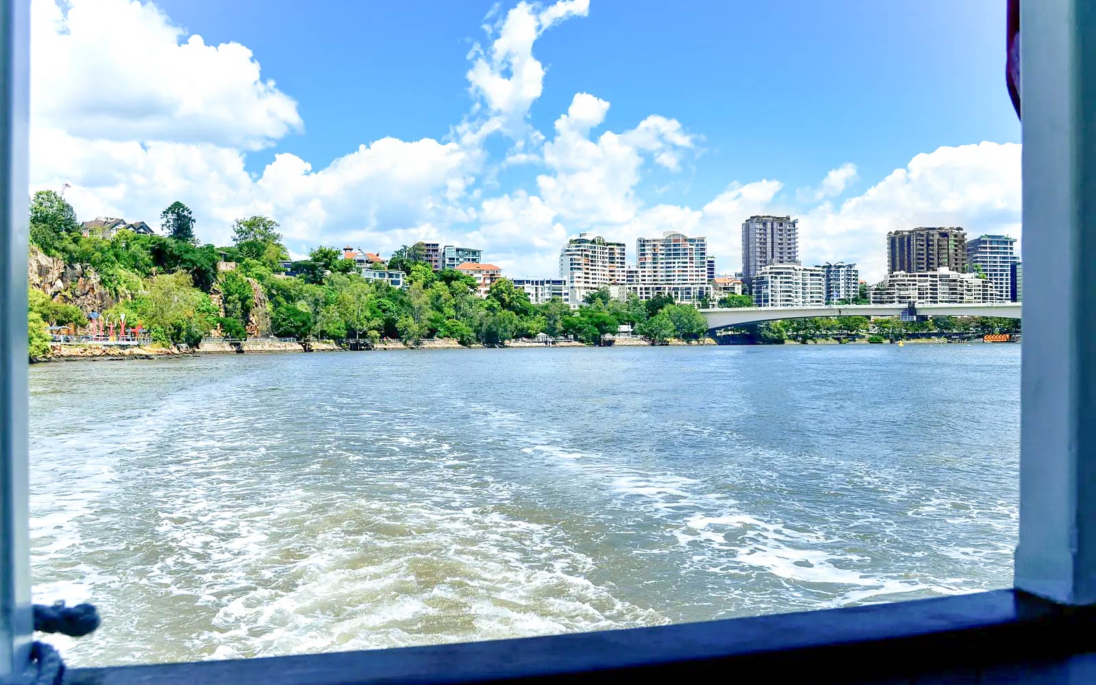 Brisbane River with city skyline and bridge viewed from a sightseeing cruise.
