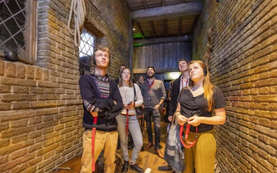 Visitors exploring an exhibit at Historium Bruges, wearing audio guides.