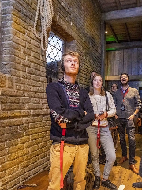 Visitors exploring an exhibit at Historium Bruges, wearing audio guides.
