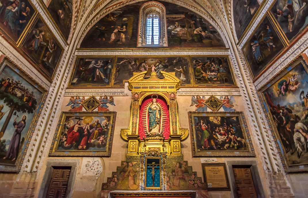 Chapel interior with religious paintings and altar inside the Cathedral of Segovia.