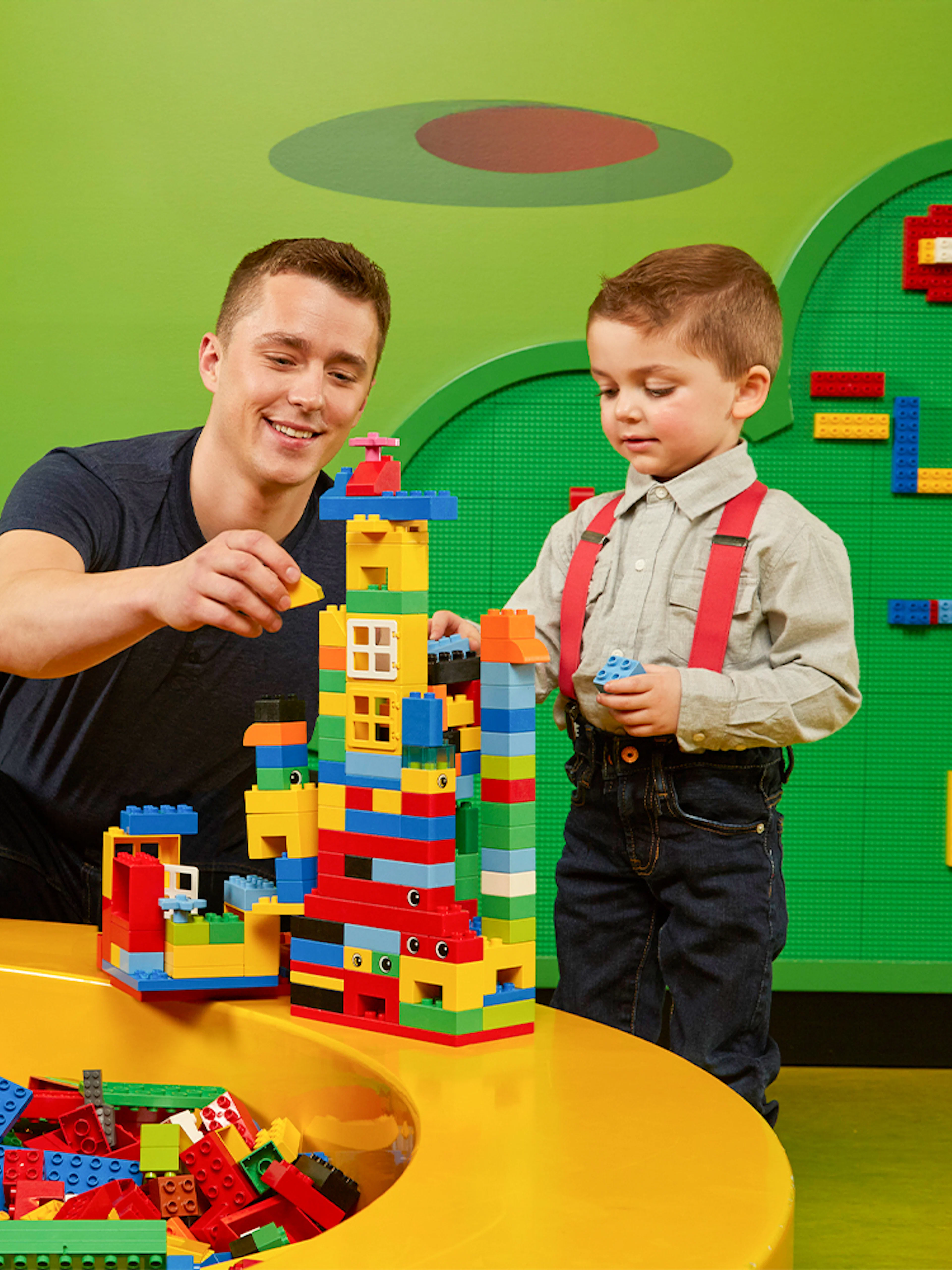 Father and child building Lego towers at LEGOLAND Discovery Centre Oberhausen.